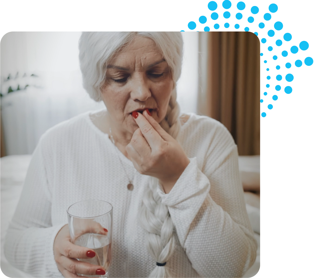 Senior woman taking an AKBA 3.0 capsule with a glass of water, demonstrating the simple daily protocol for addressing joint pain and inflammation at the source.