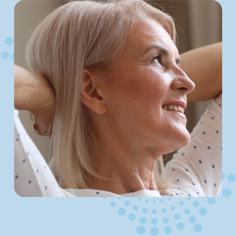 Woman with gray hair stretching her neck against a light blue background
